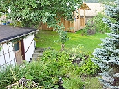 Blick auf den kleinen Gartenteich und Garage